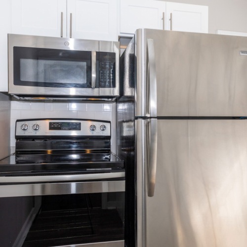 Kitchen Spacious and well lit kitchen with wood floors and stainless steel appliances