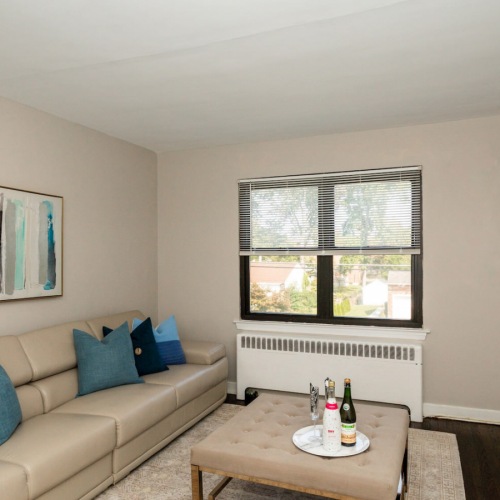 Living Room Spacious and well lit living room with wood floors and a large window with access to the kitchen