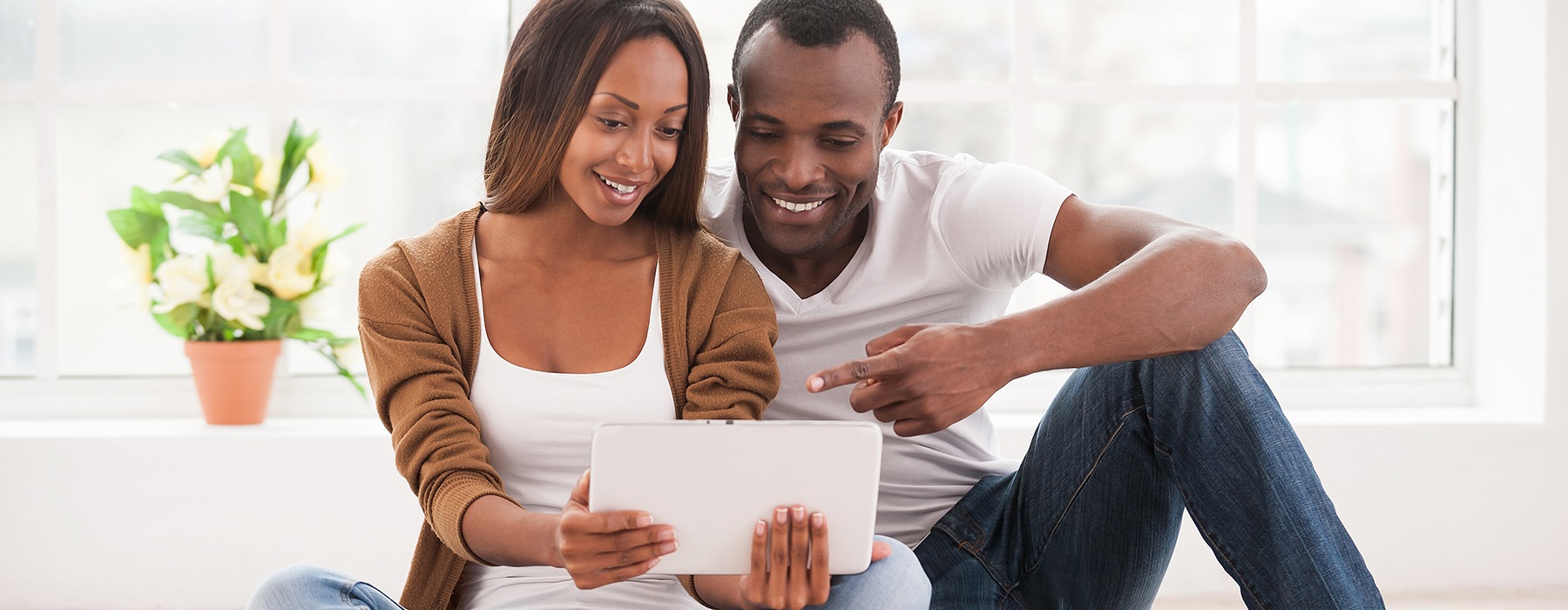 Couple smiling while looking at their IPAD
